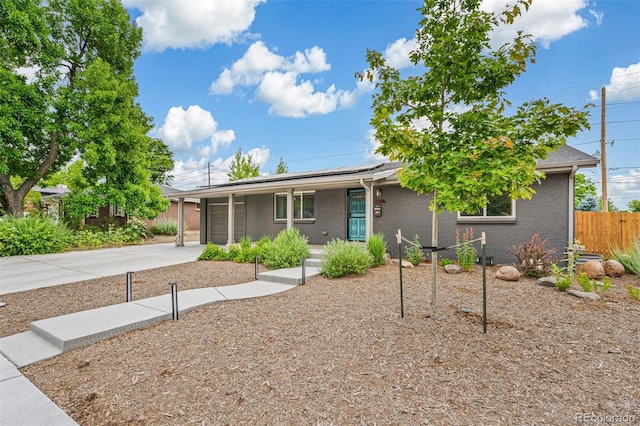 6066 Simms St, Arvada, CO 80004 - view of front facade with driveway, solar panels, an attached garage, brick siding, and a porch