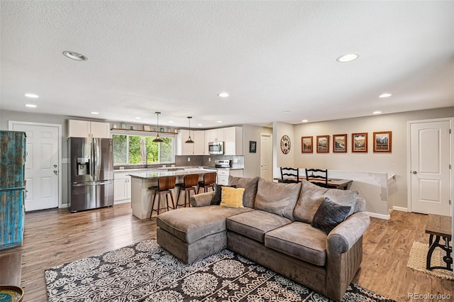 6066 Simms St, Arvada, CO 80004 - living area with recessed lighting, light wood-style flooring, and a textured ceiling