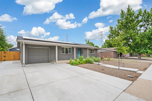 6066 Simms St, Arvada, CO 80004 - ranch-style home with an attached garage, concrete driveway, roof mounted solar panels, and a gate