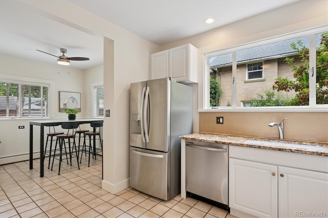 2201 Cherry St, Denver, CO 80207 - kitchen featuring appliances with stainless steel finishes, white cabinetry, ceiling fan, tasteful backsplash, and recessed lighting