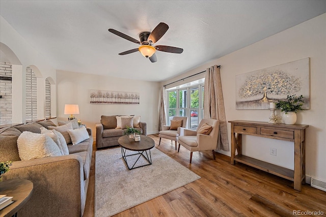 18263 E Mansfield Ave, Aurora, CO 80013 - living area featuring wood finished floors, a ceiling fan, arched walkways, and baseboards