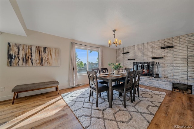 18263 E Mansfield Ave, Aurora, CO 80013 - dining space with a fireplace, a chandelier, wood finished floors, and baseboards