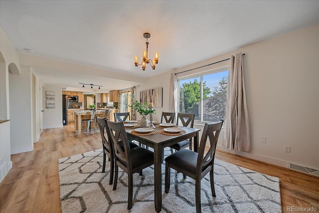 18263 E Mansfield Ave, Aurora, CO 80013 - dining space with a chandelier, light wood-style flooring, and baseboards