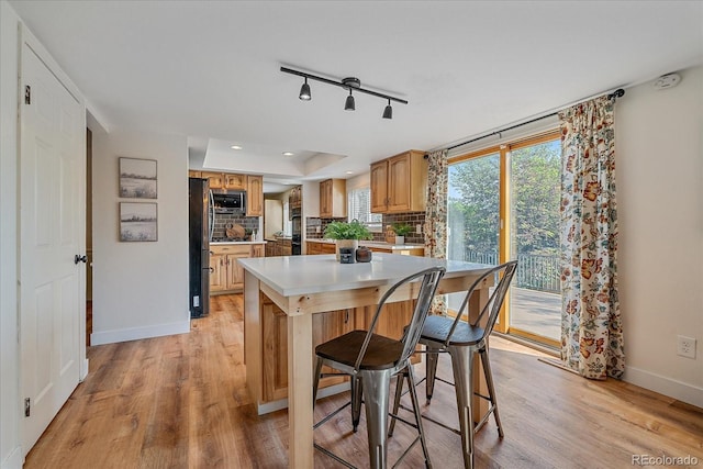 18263 E Mansfield Ave, Aurora, CO 80013 - kitchen with appliances with stainless steel finishes, light wood finished floors, baseboards, light countertops, and a kitchen island