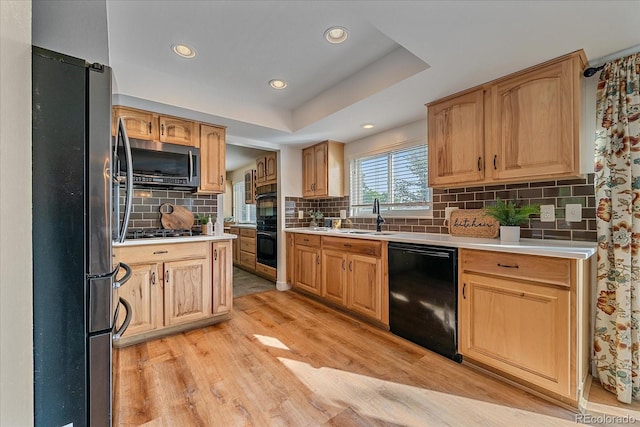 18263 E Mansfield Ave, Aurora, CO 80013 - kitchen with black appliances, light wood-style floors, a sink, light countertops, and backsplash