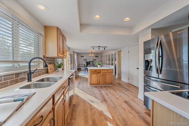 18263 E Mansfield Ave, Aurora, CO 80013 - kitchen featuring stainless steel fridge, light wood finished floors, a sink, light countertops, and decorative backsplash