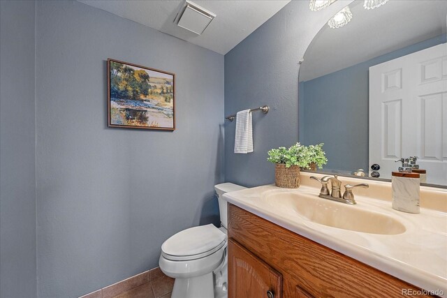 18263 E Mansfield Ave, Aurora, CO 80013 - half bath with vanity, toilet, tile patterned flooring, and baseboards