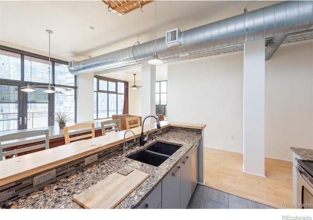 3100 Huron St Unit 3P, Denver, CO 80202 - kitchen featuring stone counters, decorative light fixtures, and stove