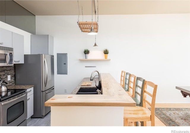 3100 Huron St Unit 3P, Denver, CO 80202 - kitchen featuring appliances with stainless steel finishes, electric panel, backsplash, open shelves, and decorative light fixtures