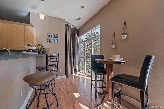 dining room with visible vents, baseboards, and wood finished floors