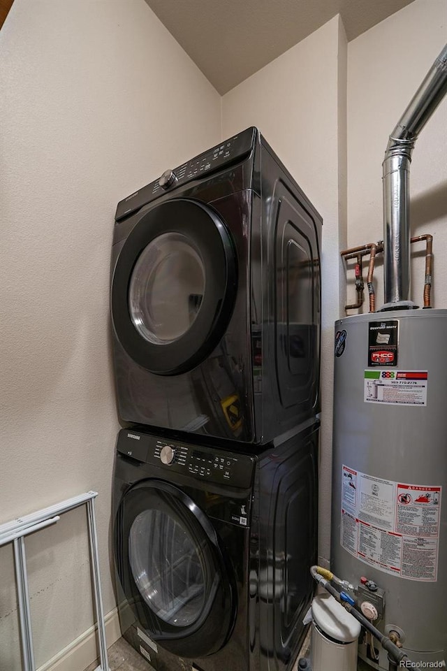 clothes washing area with stacked washer and dryer, laundry area, and water heater