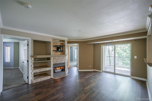 12208 W Dorado Pl Unit 207, Littleton, CO 80127 - unfurnished living room featuring a textured ceiling, crown molding, a tile fireplace, and dark wood-type flooring