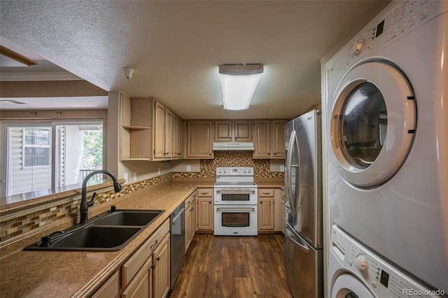 12208 W Dorado Pl Unit 207, Littleton, CO 80127 - kitchen with stainless steel appliances, under cabinet range hood, estacked washer and dryer, tasteful backsplash, and ornamental molding