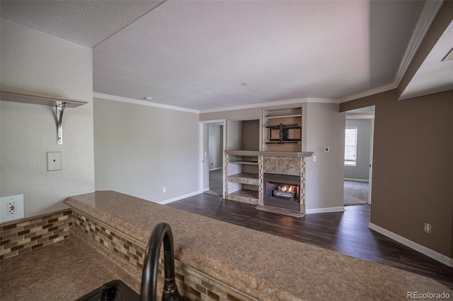 12208 W Dorado Pl Unit 207, Littleton, CO 80127 - unfurnished living room featuring dark wood-style flooring, a tile fireplace, ornamental molding, and a textured ceiling