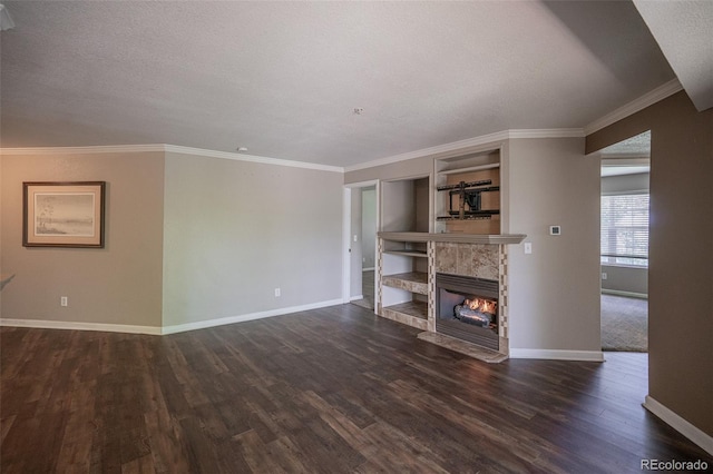 12208 W Dorado Pl Unit 207, Littleton, CO 80127 - unfurnished living room featuring dark wood finished floors, built in features, a tile fireplace, a textured ceiling, and crown molding