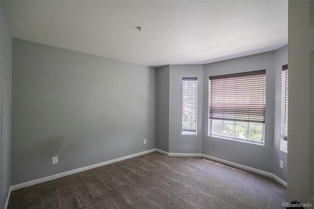 12208 W Dorado Pl Unit 207, Littleton, CO 80127 - empty room featuring dark carpet and fire sprinkler in ceiling