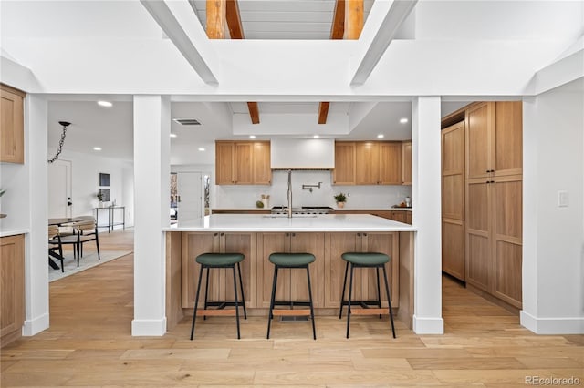 456 Cherry St, Denver, CO 80220 - kitchen with a breakfast bar area, light wood-type flooring, tasteful backsplash, light countertops, and beam ceiling