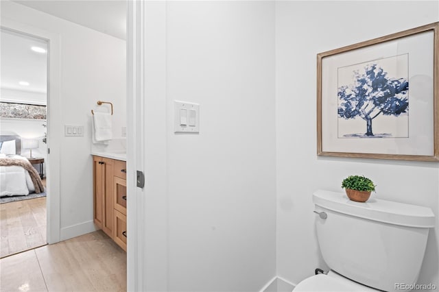 456 Cherry St, Denver, CO 80220 - bathroom featuring vanity, toilet, ensuite bathroom, wood finished floors, and baseboards