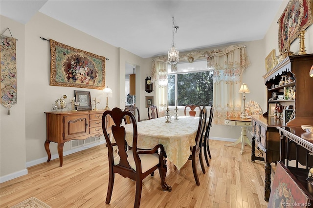 dining space with an inviting chandelier and light hardwood / wood-style floors