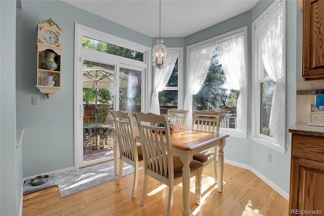 dining room with light hardwood / wood-style flooring and a chandelier