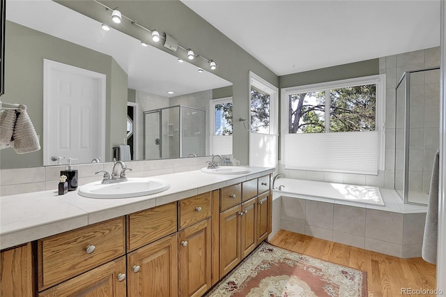 bathroom featuring vanity, hardwood / wood-style floors, and plus walk in shower