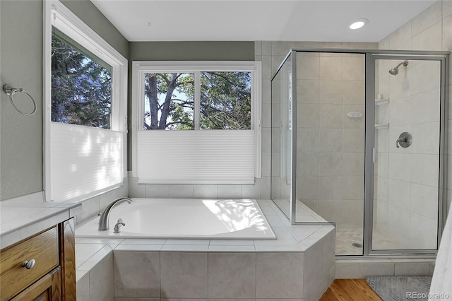 bathroom with independent shower and bath and hardwood / wood-style flooring