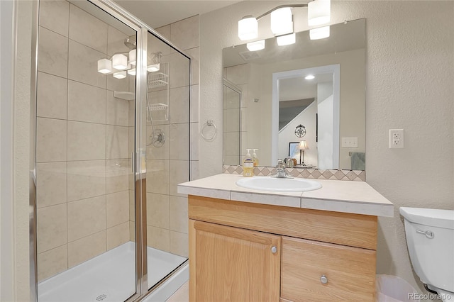 bathroom featuring vanity, toilet, and an enclosed shower