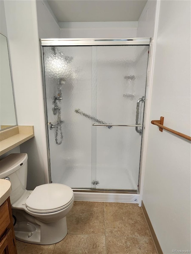 full bathroom with toilet, a stall shower, vanity, baseboards, and tile patterned floors