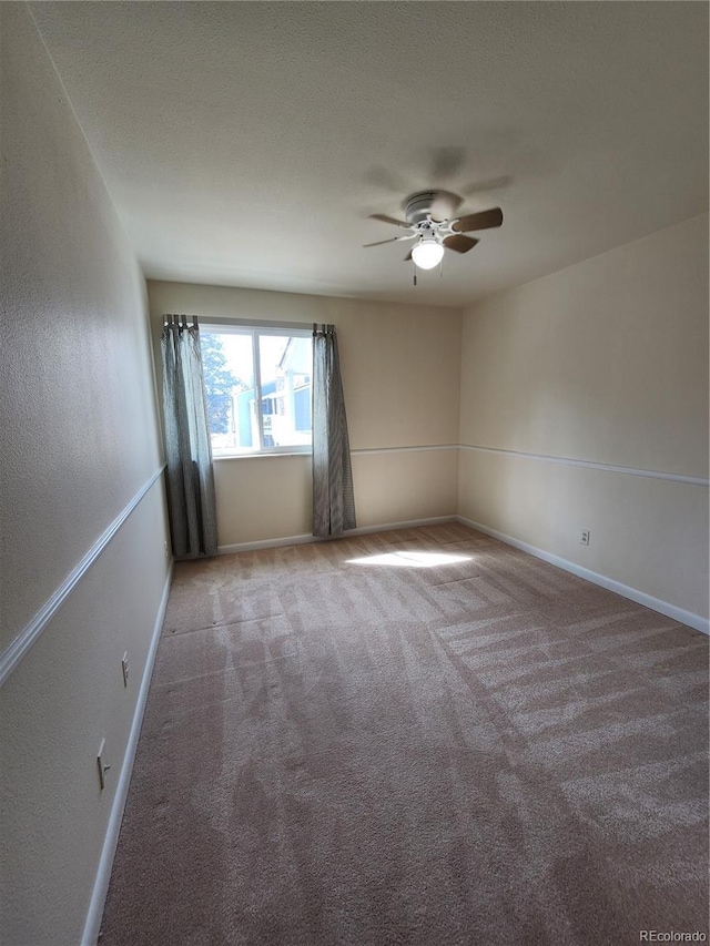 unfurnished room with carpet floors, baseboards, and a ceiling fan