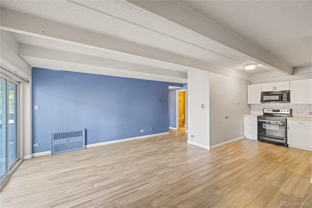 555 E 10th Ave Unit 111, Denver, CO 80203 - kitchen with electric range, black microwave, white cabinets, light wood finished floors, and baseboards