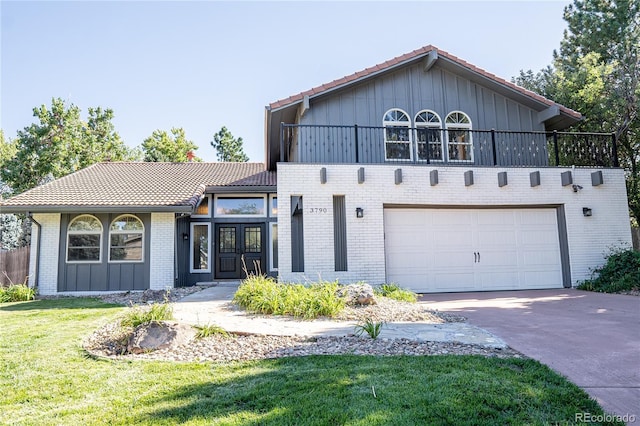 view of front of home featuring a balcony, a garage, and a front lawn