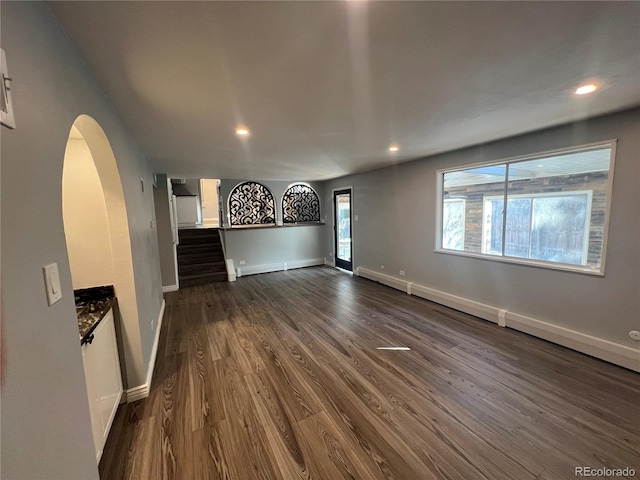 unfurnished living room featuring dark wood-type flooring