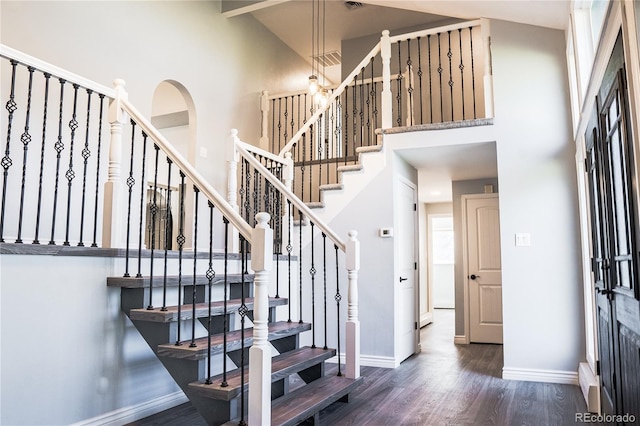 foyer entrance with a towering ceiling and dark hardwood / wood-style floors