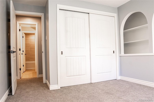 unfurnished bedroom featuring carpet flooring and a closet