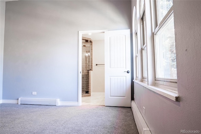 interior space with light carpet and a baseboard radiator