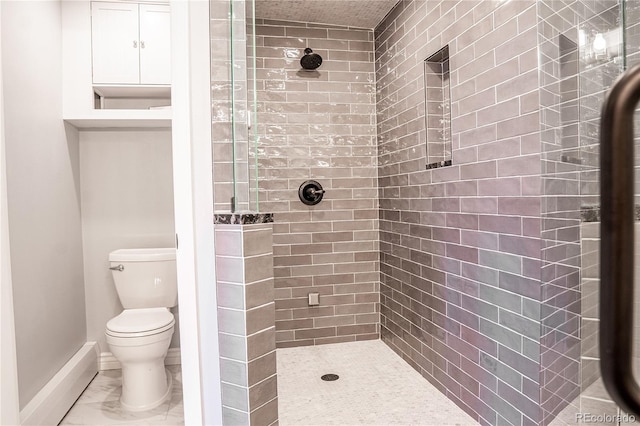 bathroom with toilet and a tile shower