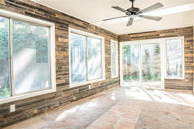 unfurnished sunroom featuring plenty of natural light and ceiling fan