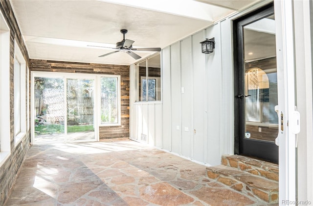 unfurnished sunroom with ceiling fan