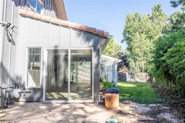 view of exterior entry featuring a yard