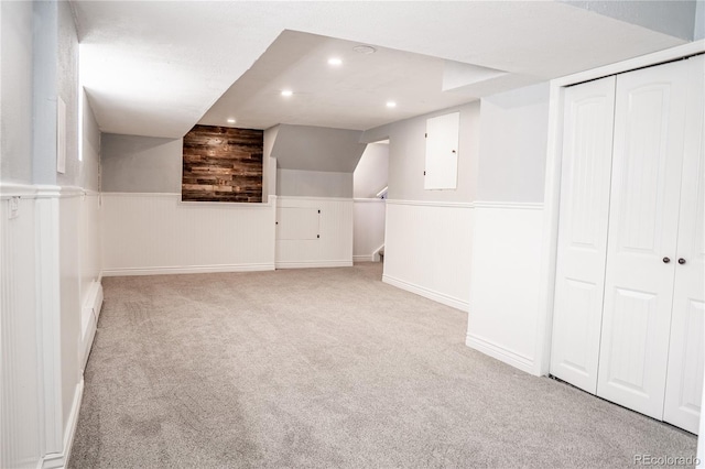 bonus room featuring electric panel, wooden walls, and light colored carpet