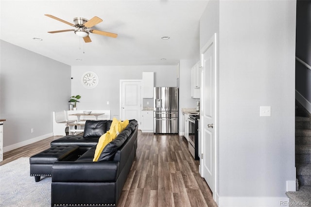 living room with ceiling fan and dark hardwood / wood-style flooring