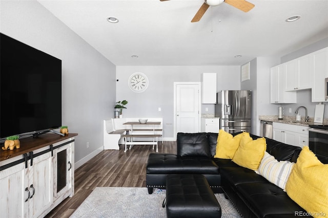 living room featuring ceiling fan, dark hardwood / wood-style flooring, and sink