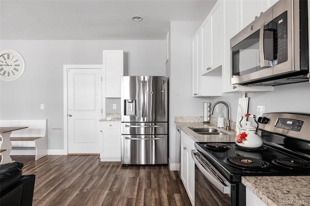 kitchen with white cabinetry, sink, stainless steel appliances, and light stone countertops