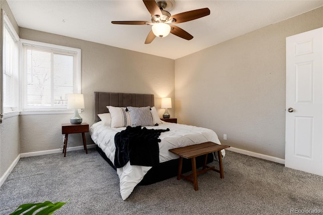 carpeted bedroom with ceiling fan, baseboards, and a textured wall