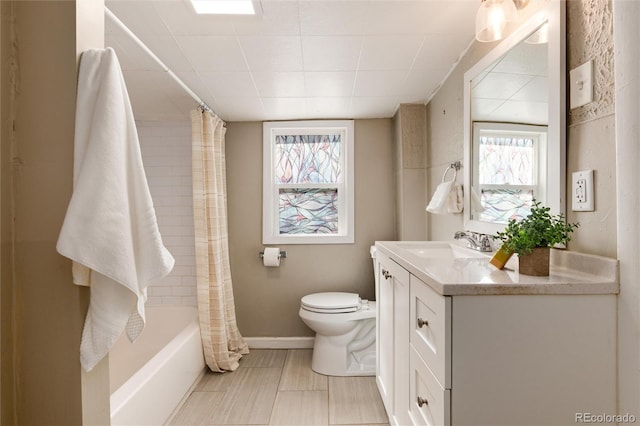 bathroom featuring toilet, vanity, and baseboards