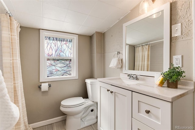 full bath with toilet, wood finished floors, a shower with shower curtain, baseboards, and vanity