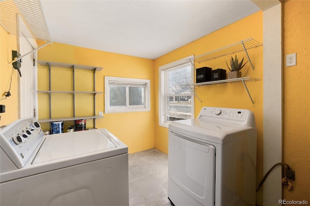 clothes washing area featuring laundry area and washer and clothes dryer