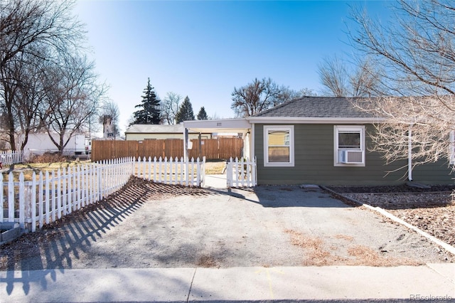 view of front facade featuring roof with shingles and fence