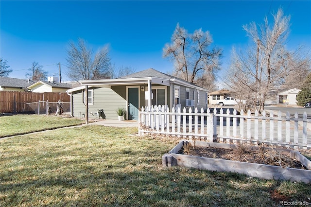 view of front of home with a garden, a front lawn, and fence