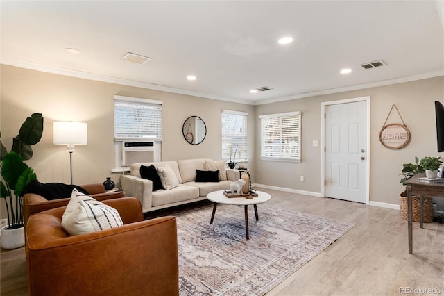 living area with light wood-type flooring, visible vents, and ornamental molding